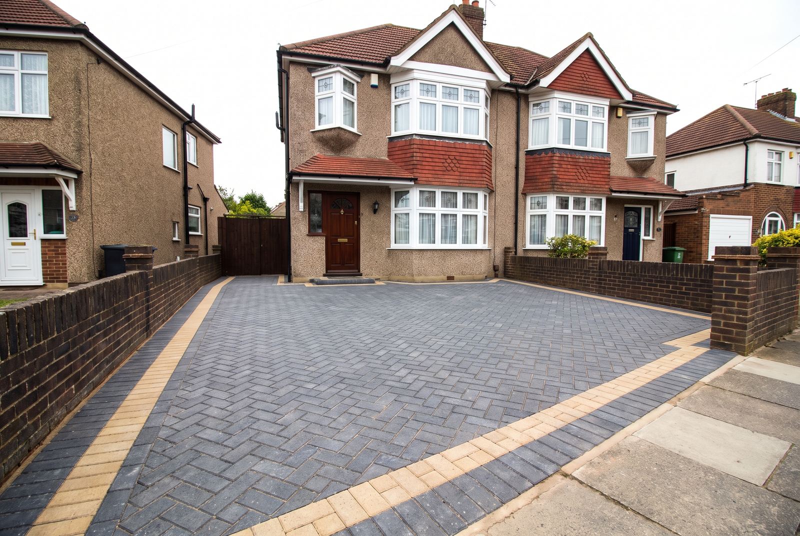 A charcoal herringbone block paving driveway at a 1930s semi detached house